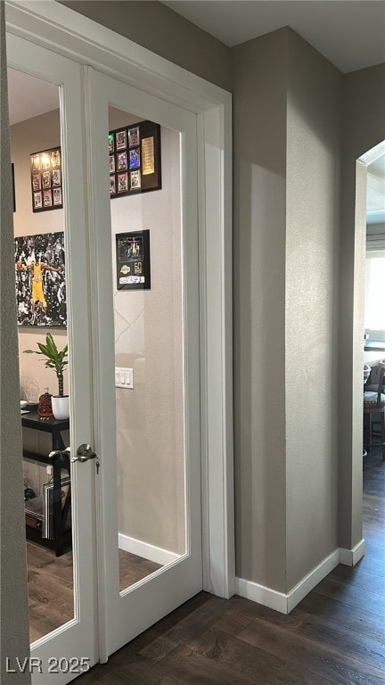 hallway with dark wood-style flooring and baseboards