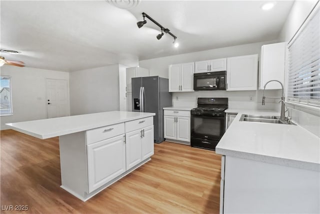 kitchen featuring a center island, sink, white cabinets, and black appliances