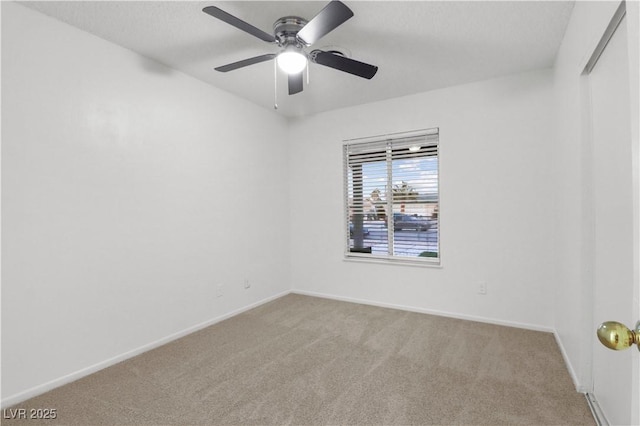 carpeted spare room with ceiling fan