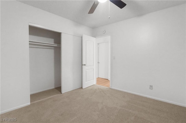 unfurnished bedroom featuring light carpet, ceiling fan, and a closet