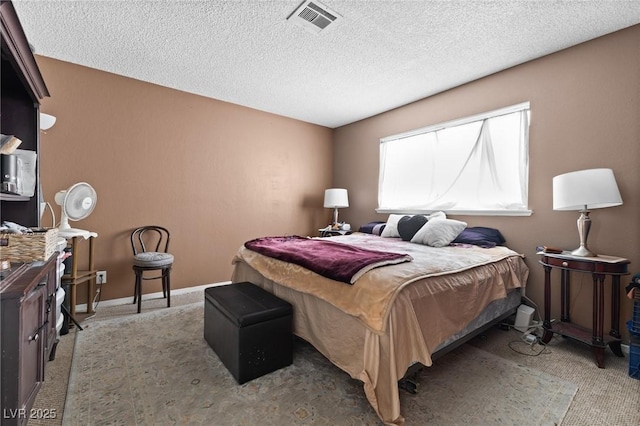 bedroom featuring light carpet and a textured ceiling