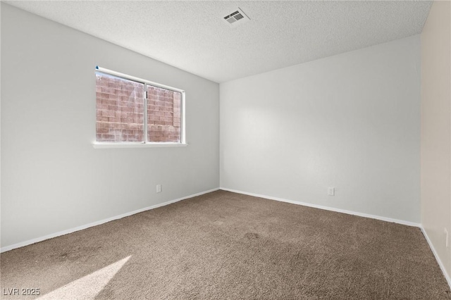 carpeted empty room with a textured ceiling