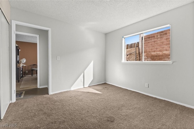 spare room with a textured ceiling and carpet flooring