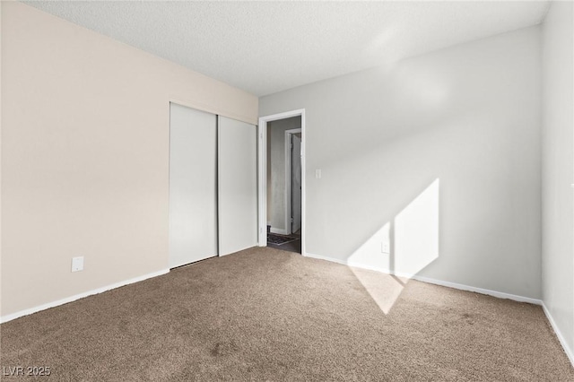 unfurnished bedroom featuring carpet floors, a closet, and a textured ceiling