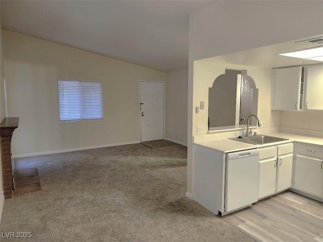 kitchen featuring sink, white cabinetry, white dishwasher, vaulted ceiling, and light colored carpet