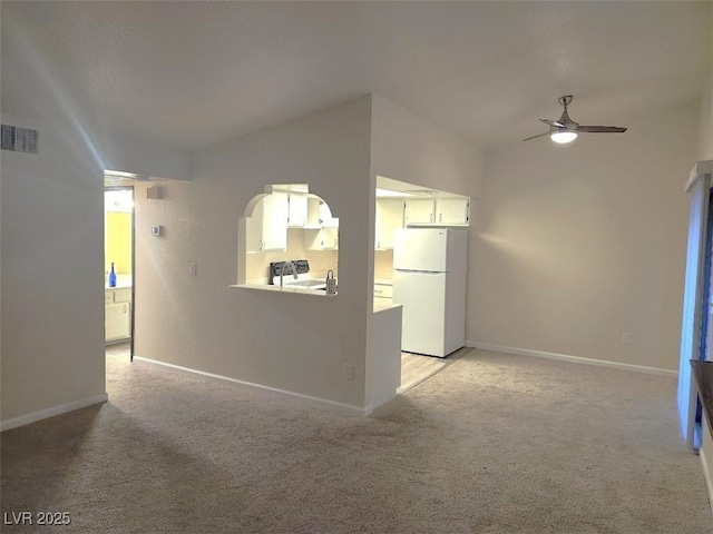 unfurnished living room featuring ceiling fan, light colored carpet, and lofted ceiling