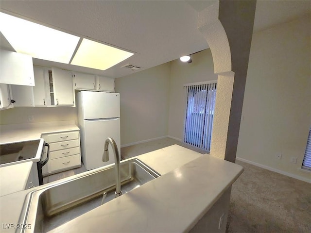 kitchen with white appliances, sink, range hood, and carpet floors