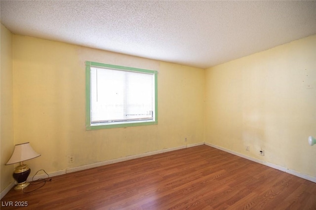 spare room with wood-type flooring and a textured ceiling