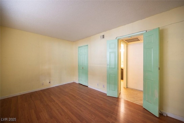 spare room with hardwood / wood-style floors and a textured ceiling