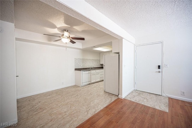 1701 E Katie Ave Unit 65, Las Vegas, NV 89119 - kitchen featuring white appliances, a textured ceiling, ceiling fan, white cabinets, and dark countertops