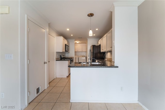 kitchen featuring white cabinetry, black refrigerator, kitchen peninsula, and hanging light fixtures