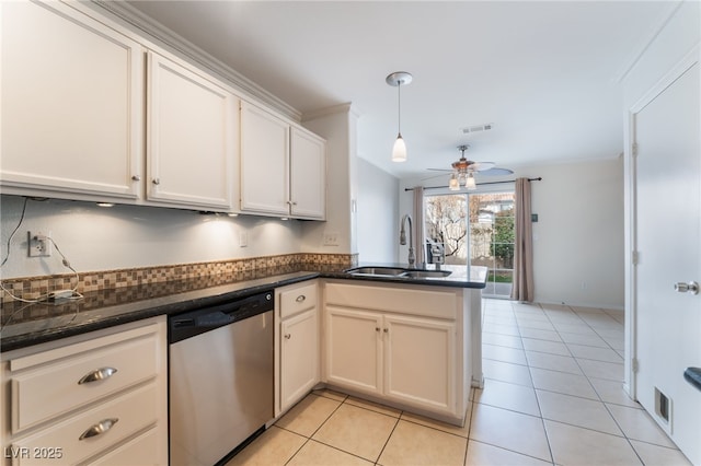 kitchen with decorative light fixtures, sink, white cabinets, stainless steel dishwasher, and kitchen peninsula