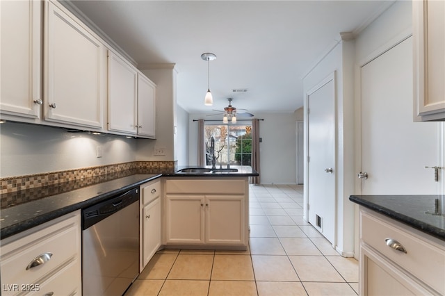 kitchen with decorative light fixtures, dark stone countertops, stainless steel dishwasher, light tile patterned floors, and kitchen peninsula