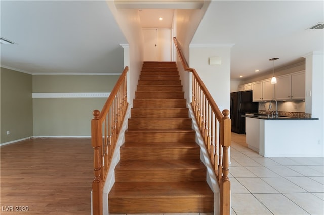 stairs featuring crown molding and tile patterned floors