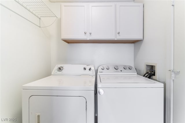 clothes washing area with cabinets and washer and dryer