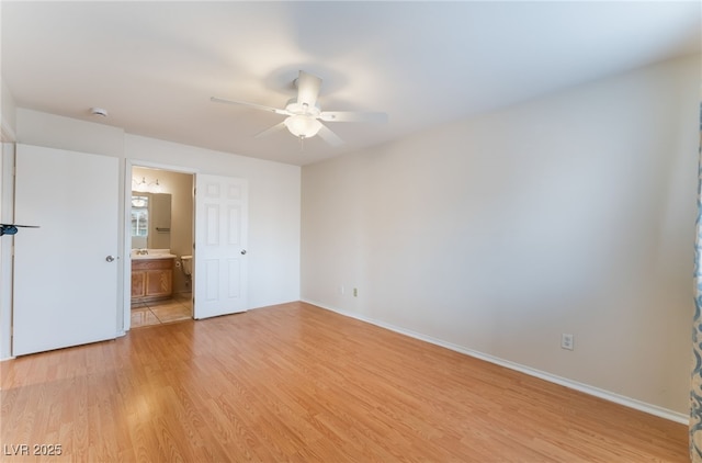 interior space featuring light hardwood / wood-style floors, ceiling fan, and ensuite bathroom