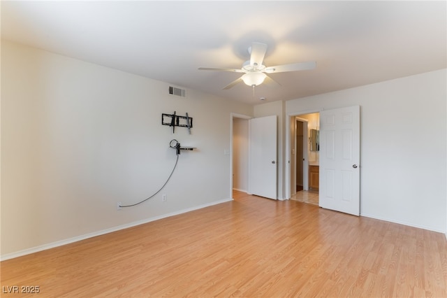 spare room with ceiling fan and light wood-type flooring