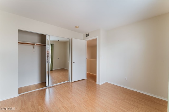 unfurnished bedroom featuring light hardwood / wood-style flooring and a closet