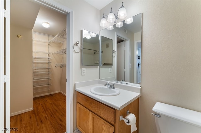 bathroom featuring vanity, hardwood / wood-style floors, and toilet