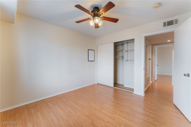 unfurnished bedroom with ceiling fan, light wood-type flooring, and a closet