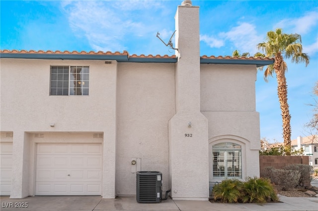 view of front of property with a garage and central AC