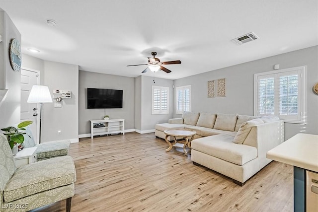 living room featuring ceiling fan and light hardwood / wood-style floors