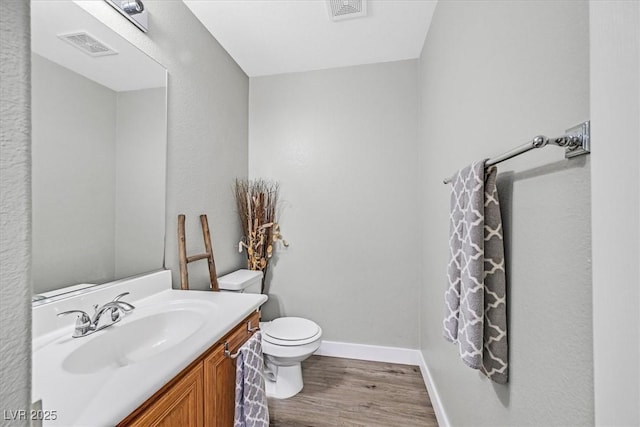 bathroom with vanity, wood-type flooring, and toilet