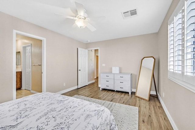 bedroom with ensuite bath, ceiling fan, and light hardwood / wood-style flooring