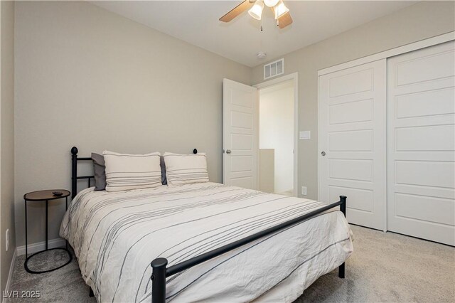 bedroom featuring baseboards, visible vents, a ceiling fan, light colored carpet, and a closet