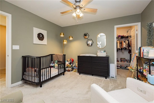 bedroom featuring carpet floors, a closet, a walk in closet, and a ceiling fan