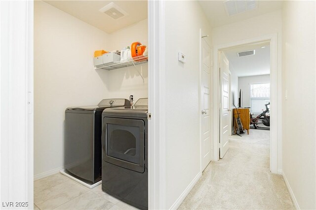 clothes washing area featuring washing machine and dryer and light carpet