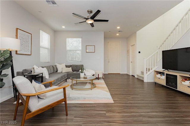 living room featuring dark wood-type flooring and ceiling fan