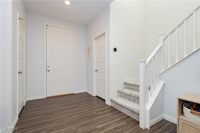 foyer entrance featuring dark wood-type flooring, recessed lighting, baseboards, and stairs