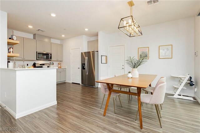 dining room with baseboards, wood finished floors, visible vents, and recessed lighting