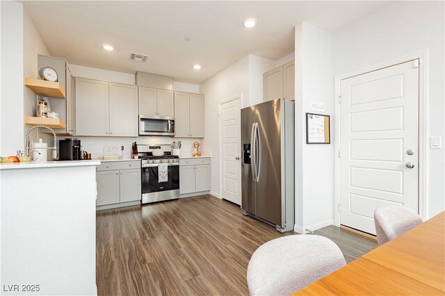 kitchen featuring visible vents, dark wood-type flooring, stainless steel appliances, light countertops, and open shelves