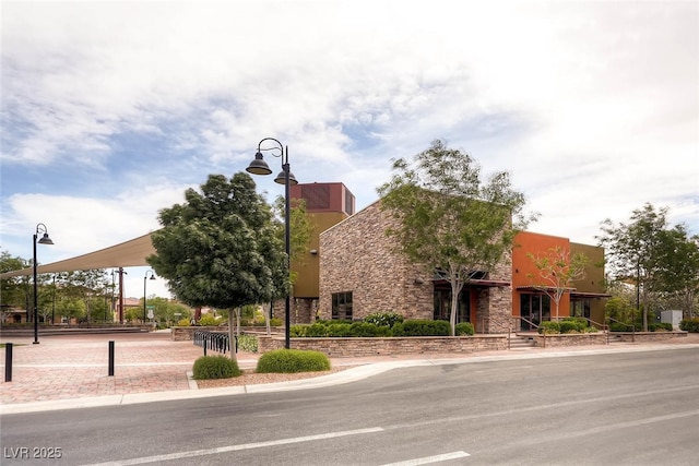 exterior space featuring stone siding and stucco siding