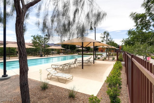 community pool featuring fence and a patio