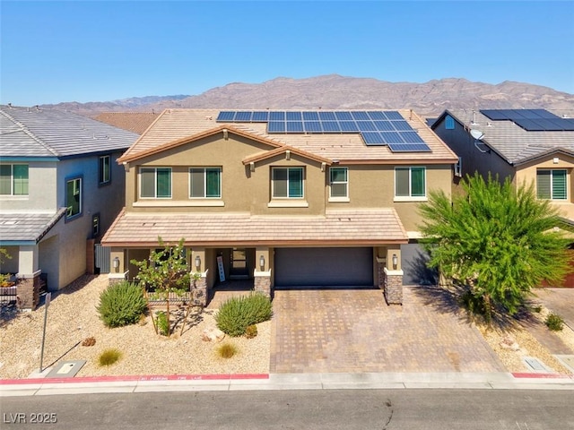 view of front facade with a mountain view, a garage, and solar panels