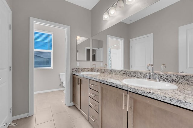 bathroom with tile patterned flooring, vanity, and toilet