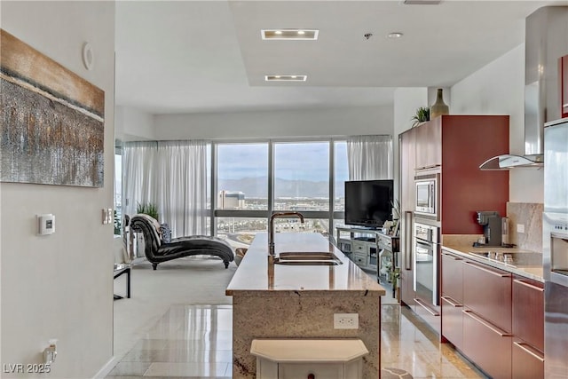 kitchen featuring stainless steel appliances, sink, and a center island with sink