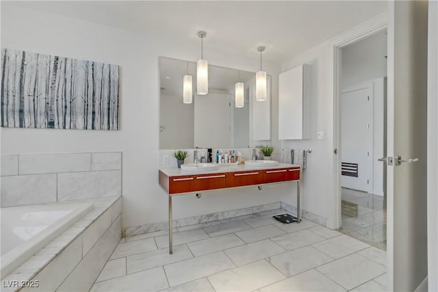 bathroom featuring vanity, tiled bath, and tile patterned floors