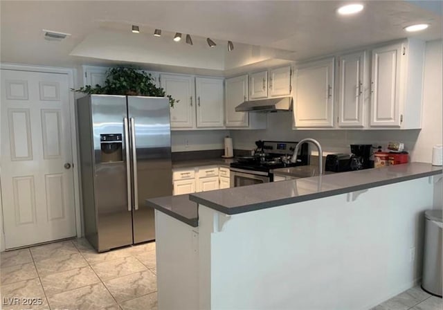 6250 W Flamingo Rd Unit 88, Las Vegas, NV 89103 - kitchen with stainless steel appliances, a breakfast bar, white cabinets, and kitchen peninsula