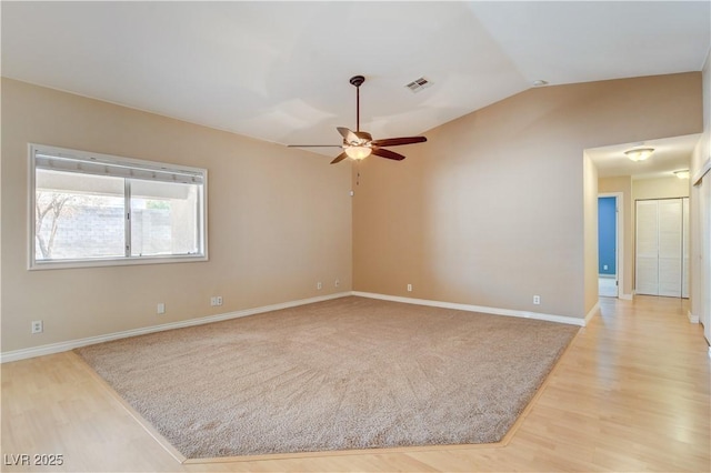 spare room with lofted ceiling, ceiling fan, and light hardwood / wood-style flooring