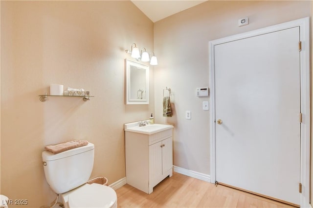 bathroom featuring wood-type flooring, vanity, and toilet