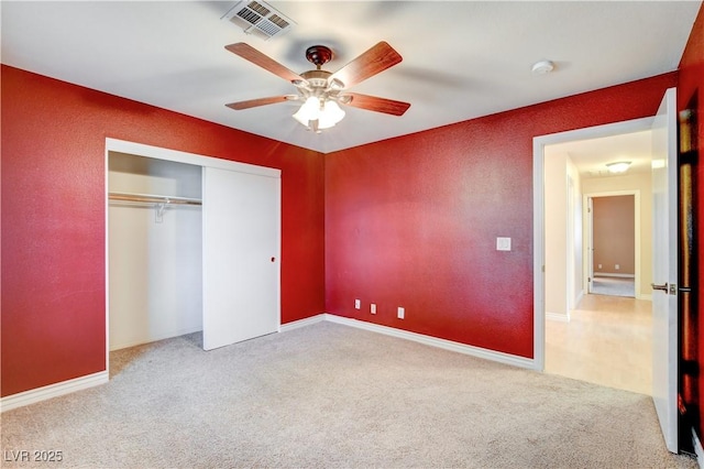 unfurnished bedroom with ceiling fan, a closet, and light carpet