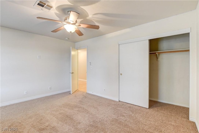 unfurnished bedroom with light carpet, a closet, and ceiling fan