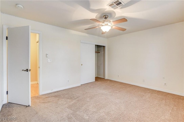 unfurnished bedroom with light carpet, ceiling fan, and a closet