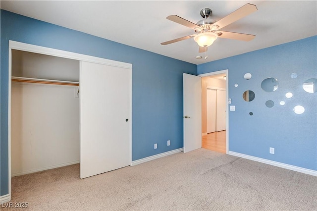 unfurnished bedroom featuring ceiling fan, light colored carpet, and a closet