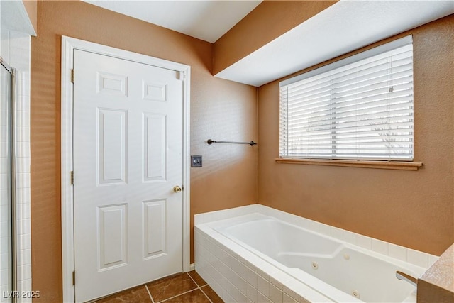 bathroom with a relaxing tiled tub and tile patterned floors