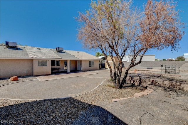 rear view of property with central AC unit and a patio area